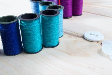 Rainbow of colourful thread spools on the table Stock Photos