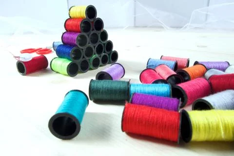 Rainbow of colourful thread spools on the table Stock Photos