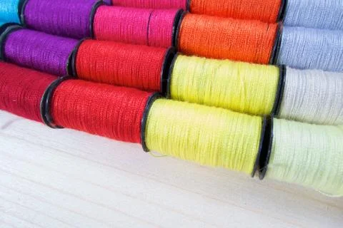 Rainbow of colourful thread spools on the table Stock Photos