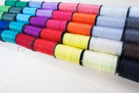 Rainbow of colourful thread spools on the table Stock Photos