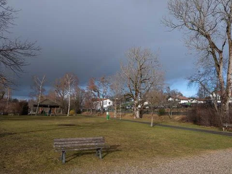 Rainbow with dark clouds of a storm over a park Stock Photos
