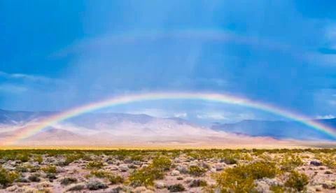 Rainbow on the desert in daylight Stock Photos