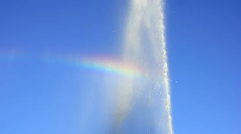 Rainbow, drawn by a stream of a fountain. Stock Photos