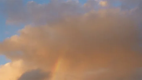 Rainbow during storm with orange sunset glow on clouds Stock-Footage 80458159