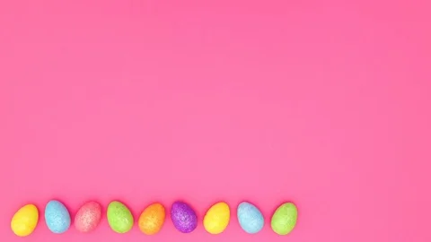 Rainbow eggs for Easter moving on bottom of pink background - Stop motion Stock Footage 124354285