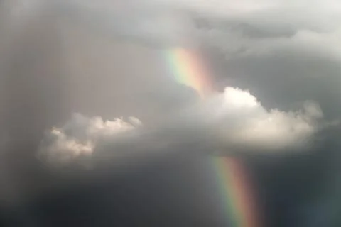 Rainbow emerging through dramatic clouds. Horizontal orientation Fotos Stock