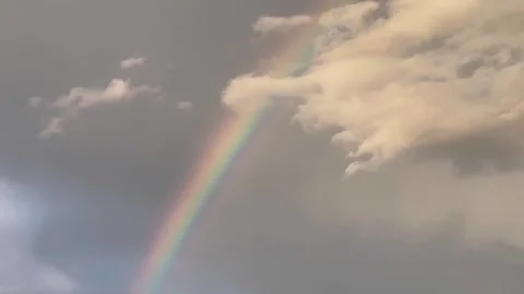 Rainbow emerging through overcast sky in slow zoon in motion 스톡 동영상 344054178