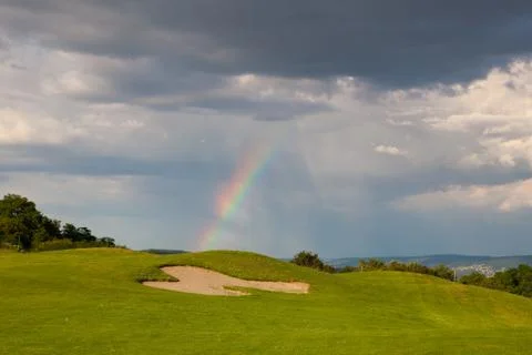 Rainbow on the empty driving range 库存照片