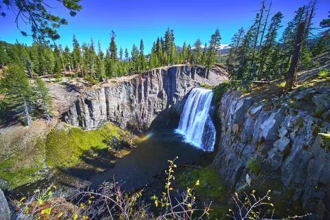 Rainbow Falls Waterfall Cascading Over Devils Postpile Cliffs Surrounded by Pine Stock Photos