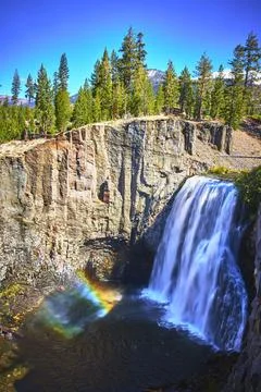 Rainbow Falls Waterfall with Vibrant Rainbow and Pine Forest in Devils Postpile Stock Photos