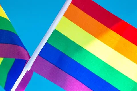 Rainbow Flag flapping in the wind, Gay Pride or LGBT Flag on blue sky backgro Stock Photos