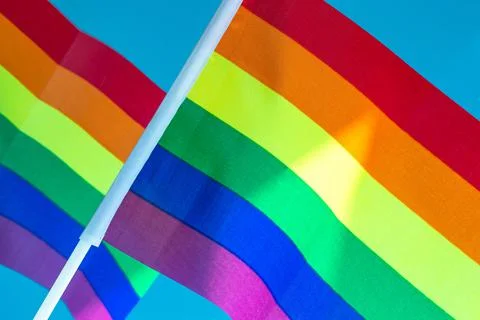 Rainbow Flag flapping in the wind, Gay Pride or LGBT Flag on blue sky backgro Stock Photos