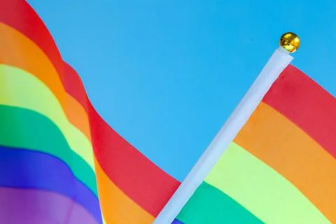 Rainbow Flag flapping in the wind, Gay Pride or LGBT Flag on blue sky backgro Stock Photos