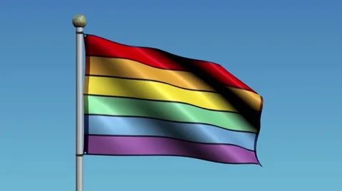 Rainbow Flag Flaps in the Wind Against a Blue Sky 库存影片 59665367