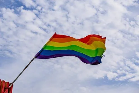 A rainbow flag is flying in the sky Stock Photos