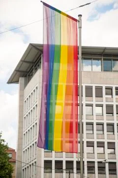 Rainbow flag in front of the windows of a large building Stock Photos