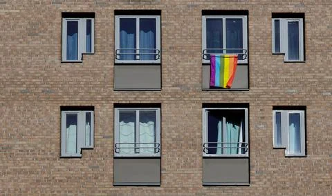 Rainbow Flag outside window of brick building. Tolerance symbol Foto stock