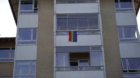 Rainbow flag. A rainbow flag hangs on the balcony of a residential building. Stock Footage 232968237