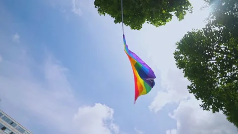 Rainbow Flag Spinning Against Blue Sky During Pride Event Stock Footage 340504506