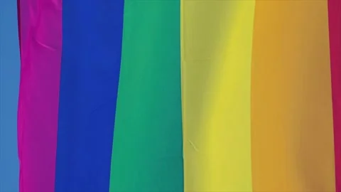 Rainbow flag in sunshine against blue sky Видео 169481939