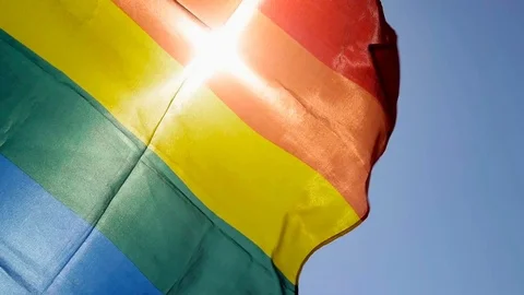 Rainbow flag waving on the blue sky Stock Footage 111011304