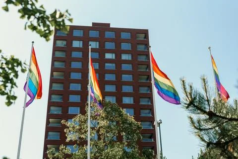 Rainbow flags waving with a building in the background Fotos de archivo