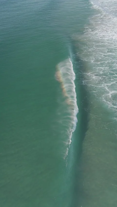 Rainbow Forming Behind Ocean Wave at Seven Mile Beach, Australia Stock Footage 342681543