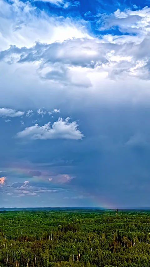 Rainbow Forms in Moving Clouds Above Forest Latvia Aerial Timelapse Stock Footage 343923546
