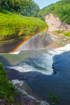 A rainbow forms at the top of a waterfall at Letchworth State Park Stock Photos