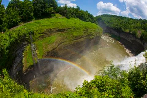 A rainbow forms at the top of a waterfall at Letchworth State Park Stock Photos
