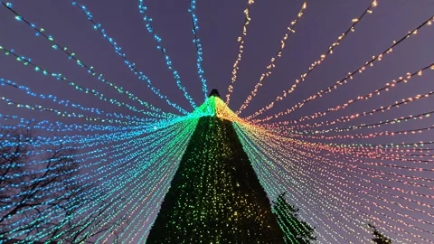 Rainbow garlands in the shape of a Christmas tree on a city street Stock Footage 297394584