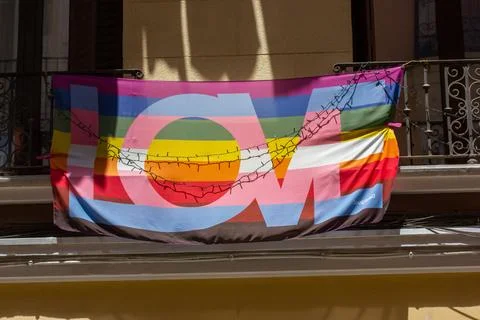 Rainbow gay LGBT flag text LOVE on balcony of an apartment building Pride Month Stock Photos