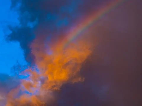 Rainbow Glowing Through Dramatic Orange and Blue Storm Clouds Stock Photos