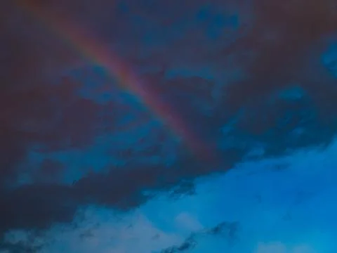 Rainbow Glowing Through Dramatic Orange and Blue Storm Clouds Stock Photos