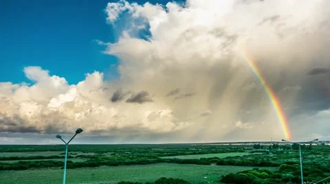Rainbow, green field and clouds on the sky. 4k, Time lapse Stock Footage 57859299