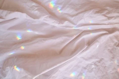 Rainbow highlights on a cotton sheet. Stock Photos