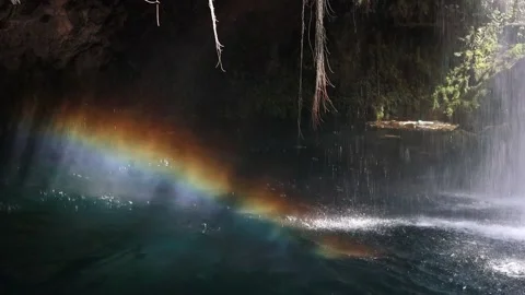 Rainbow in the jets of water when the waterfall falls into the lake Stock Footage 219431675