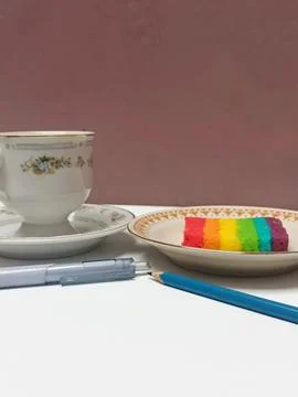 Rainbow Layer Cake Slice with Coffee Cup and Pen Stock-Fotos