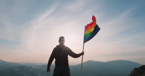 Rainbow LGBT flag. Man holding the rainbow waving flag Stock Footage 242944714