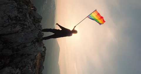 Rainbow LGBT flag on sunset sky Stock Footage 242808934