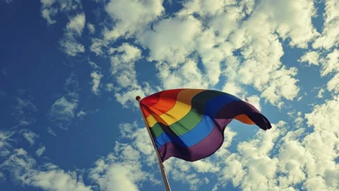 Rainbow LGBT+ pride flag soars against an expansive sky Video stock 317021614