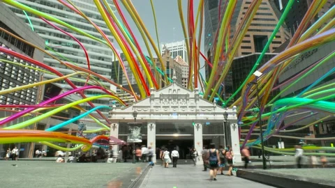 Rainbow licorice candy laces flying through cityscape Stock Footage 149838800