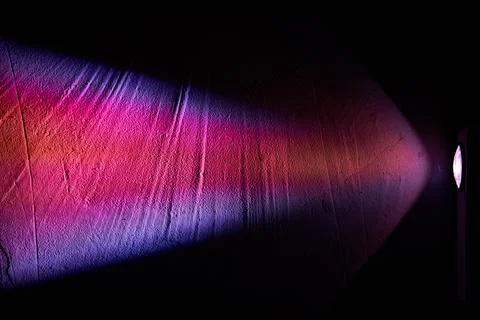 Rainbow light from the projector. Multicolored rays on a dark background Stock Photos