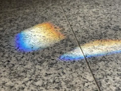 Rainbow light refraction on grey surface Stock Photos