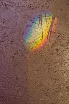 Rainbow light spot and shadows on textured plywood surface Stock Photos
