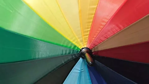 Rainbow multi coloured umbrella whirling around at speed Stock Footage 308652483