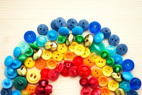 Rainbow from multicolored button on wooden background Stock Photos