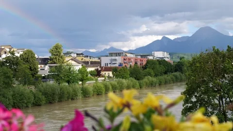 Rainbow over alpine river town and mountains after spring rain Stock Footage 341664803