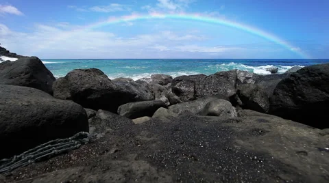 Rainbow over a beach with lava rocks in Hawaii Stock-Footage 56235759