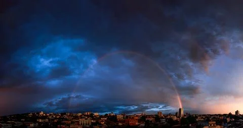 Rainbow Over Dramatic City 스톡 사진
